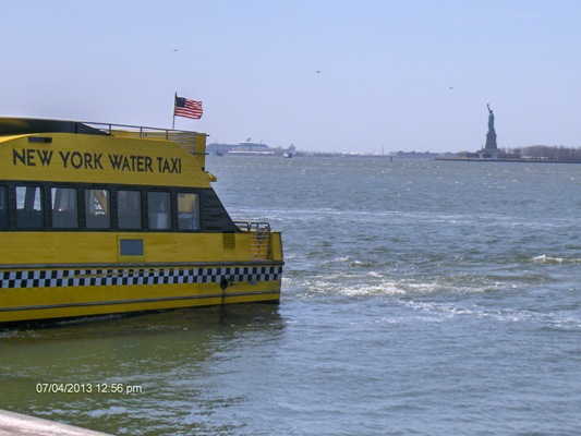 Water taxi driving by the Statue of Liberty